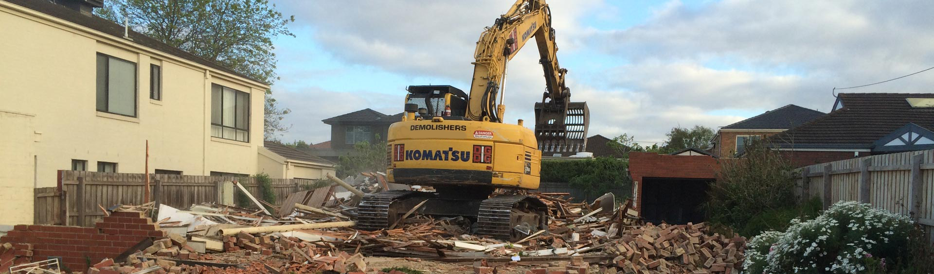 backhoe at house demolition site
